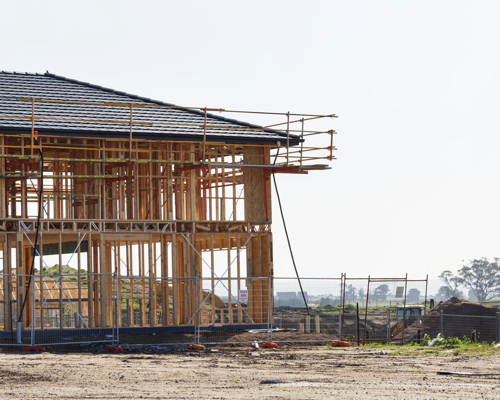 New home under construction, wood framing against a clear sky